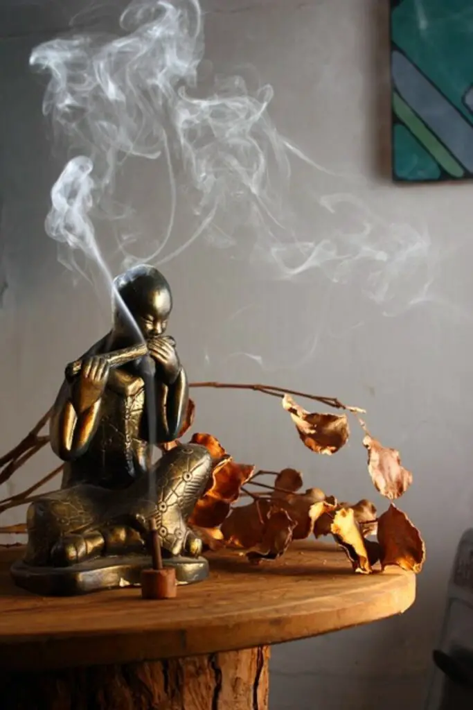 figurine playing flute with incense